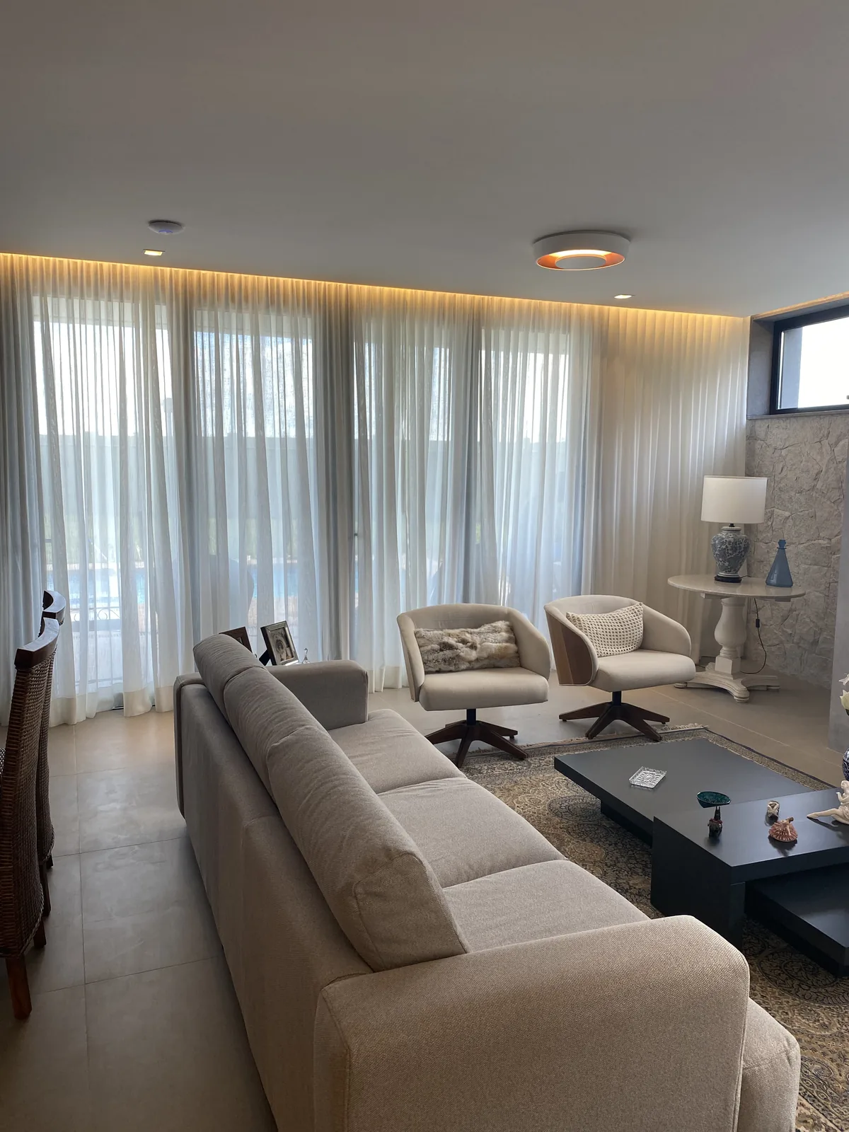 Sala com cortina de tecido leve cobrindo uma ampla abertura