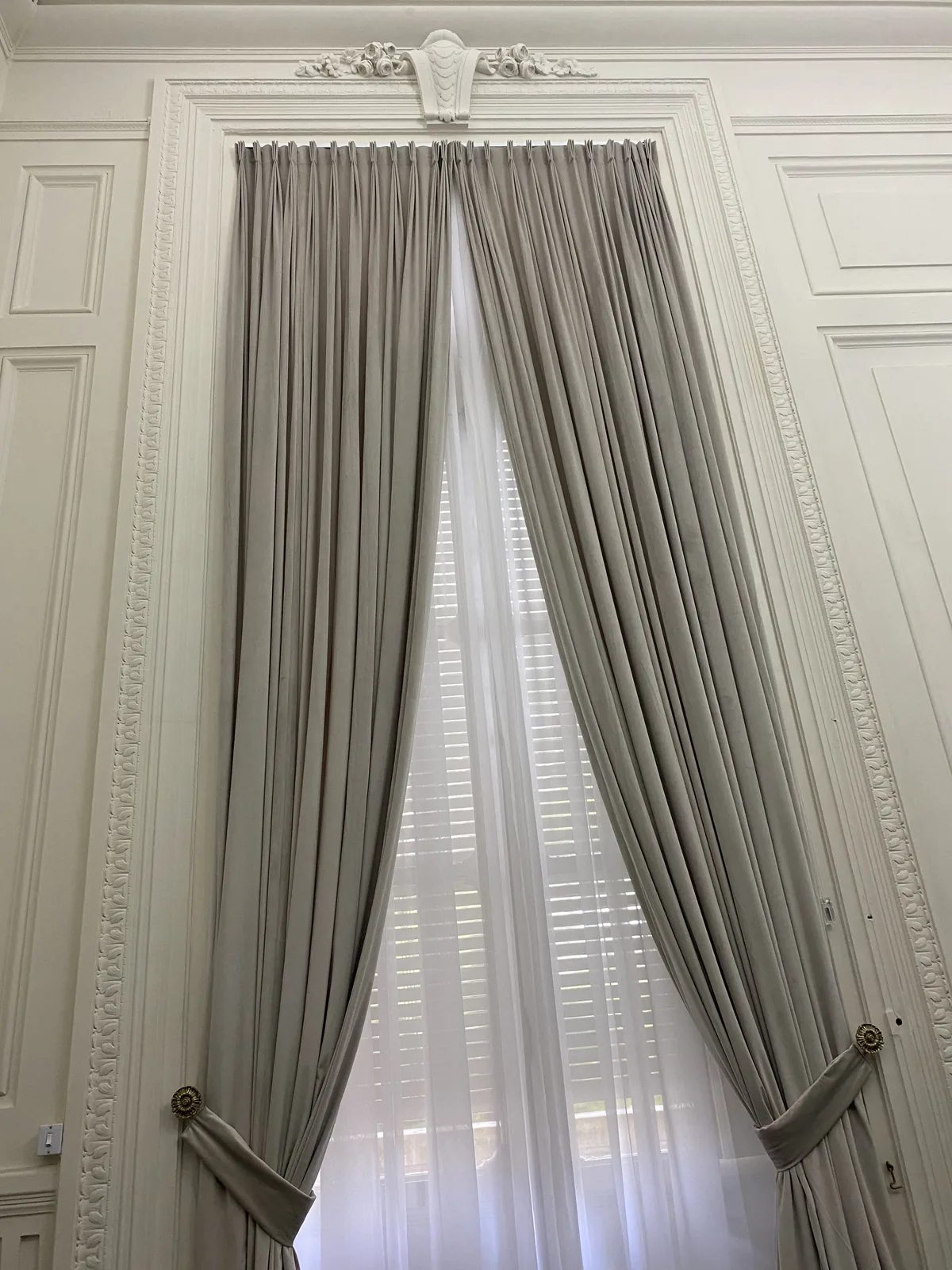 Cortina de tecido instalada em uma janela de pé-direito alto